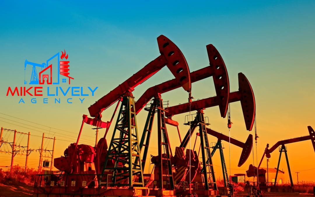 Oil pumpjacks operating in a field during sunset, with the sky transitioning from blue to orange. The logo of Mike Lively Agency, featuring an oil rig, a building, and a flame, is prominently displayed in the upper left corner.